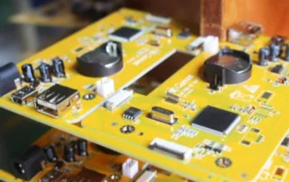 Two yellow PCB circuit boards stacked in a hardware enclosure, showing chips, connectors, and various components.