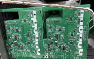 Two densely populated green PCB boards inside a metal chassis, with numerous connectors, resistors, and ICs.