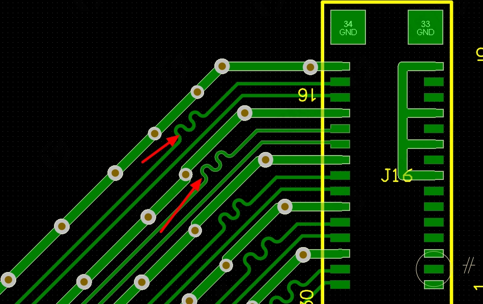Close-up of a PCB: diagonal green signal traces with round vias, red arrows indicating bend areas, and a yellow outline around a connector area labeled J16 (GND pads nearby).