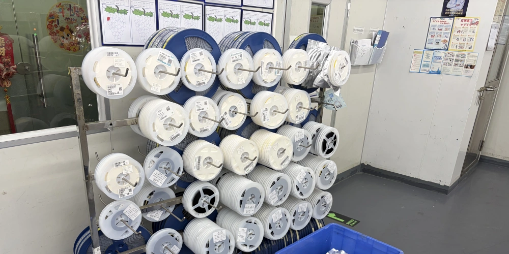 Control component sourcing and substitutions Labeled reels of electronic components staged on a rack beside material bins