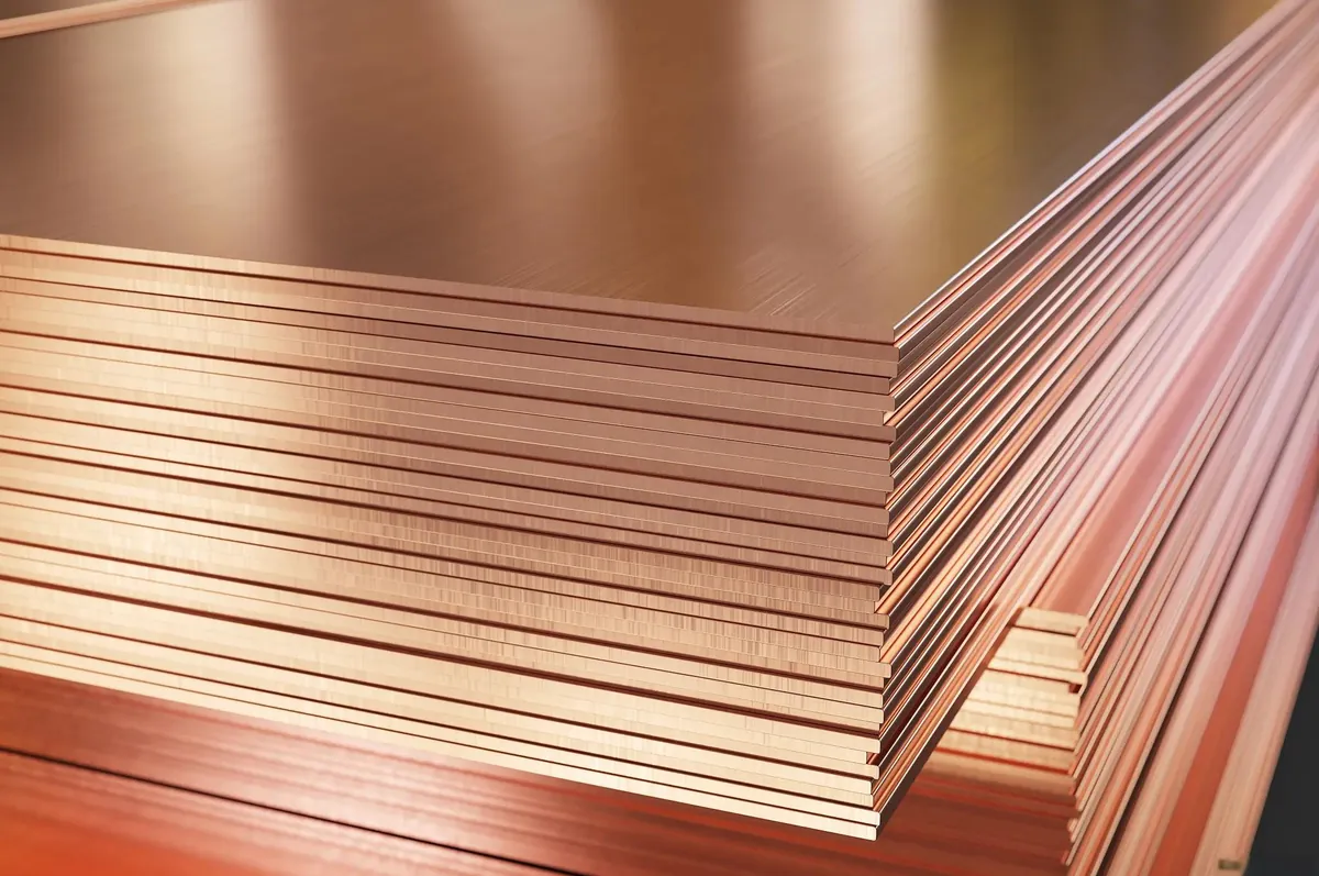 Stacked copper-colored metal sheets showing flat faces and exposed edges