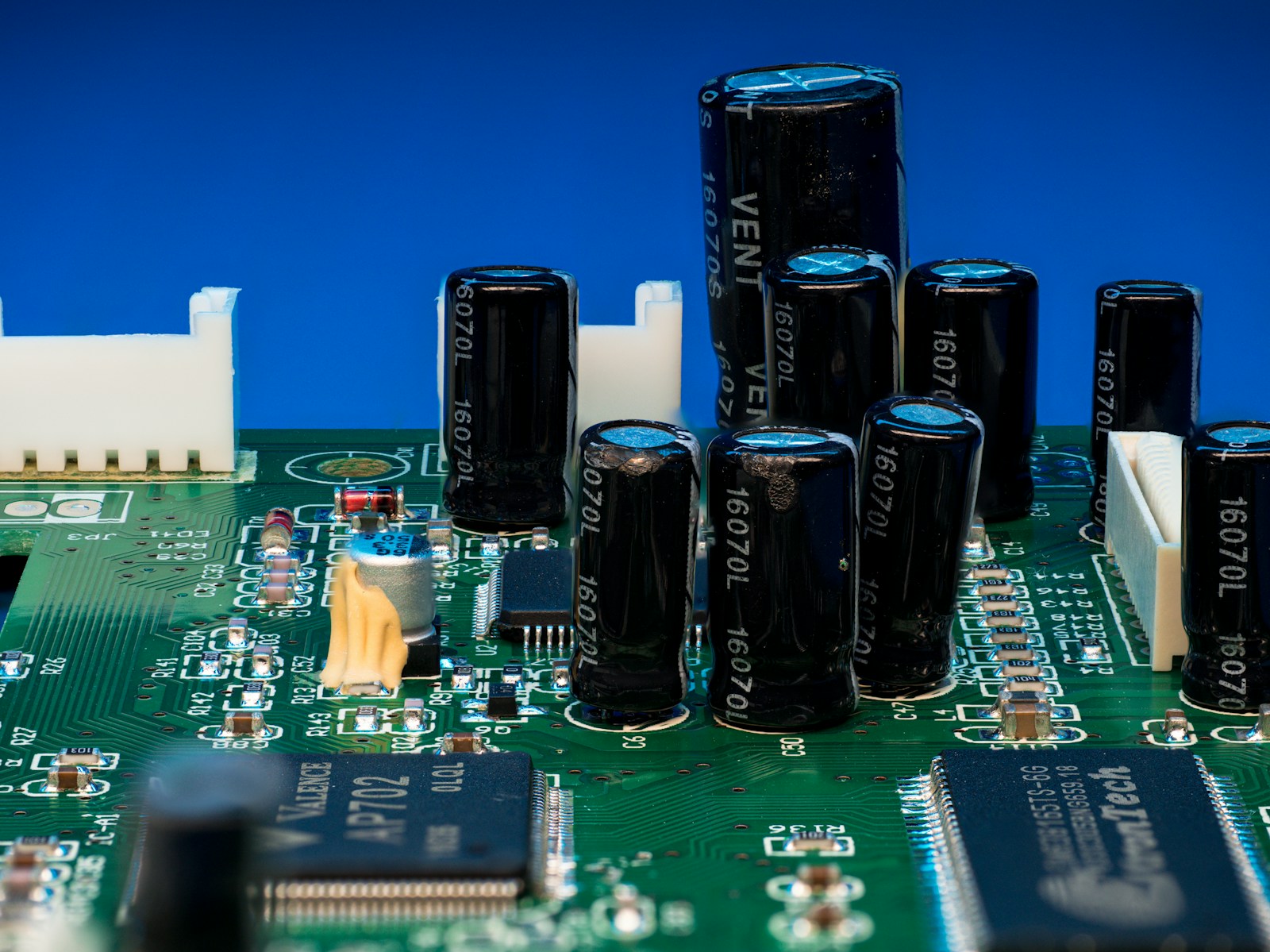 Electronic circuit board with IC packages, capacitors, connectors and visible copper routing