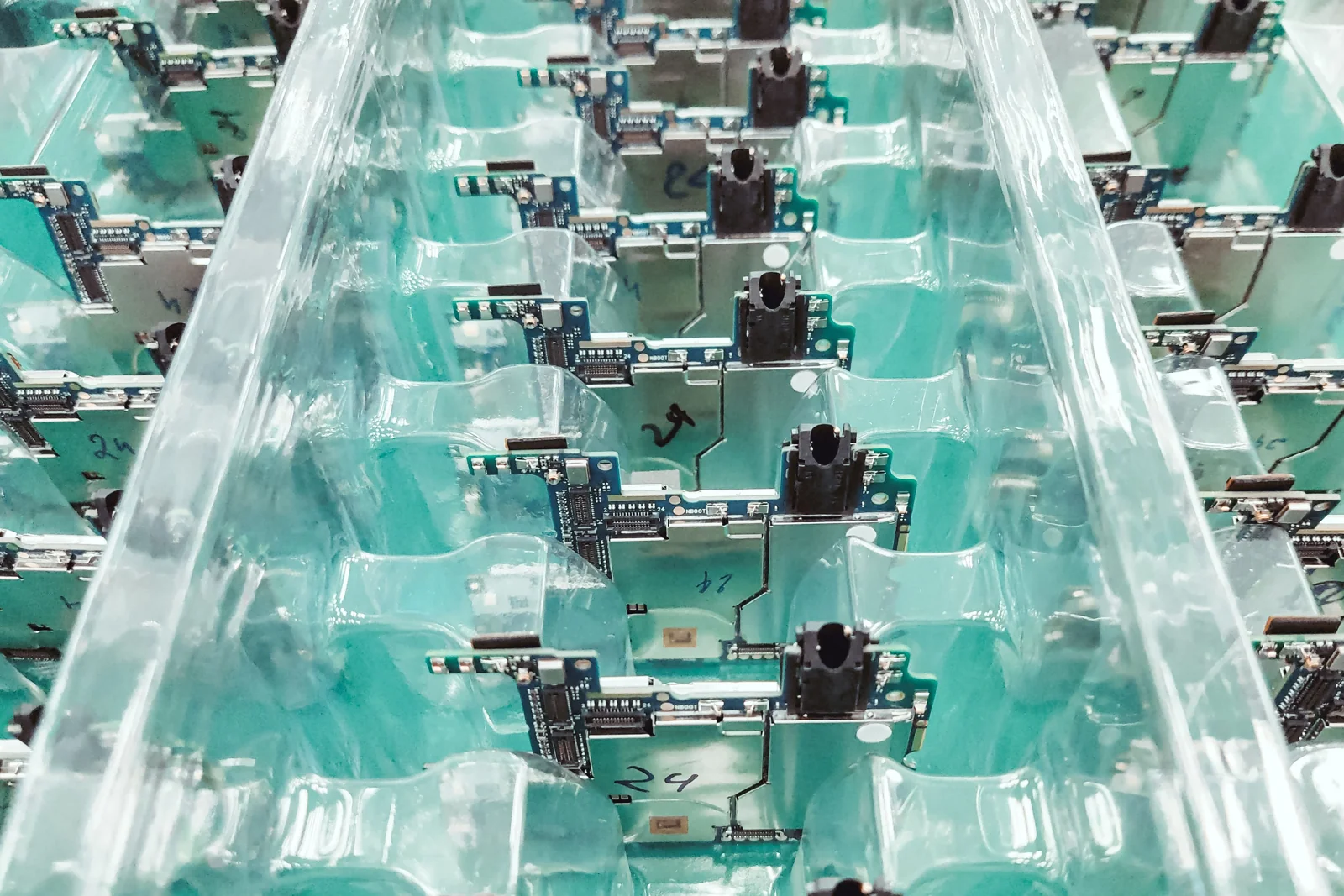 Assembled circuit boards arranged in rows on production fixtures