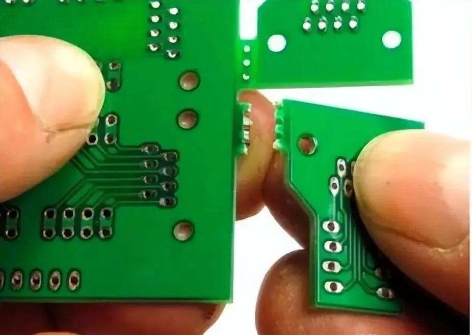 PCB separated at a perforated breakaway tab with rough edges visible